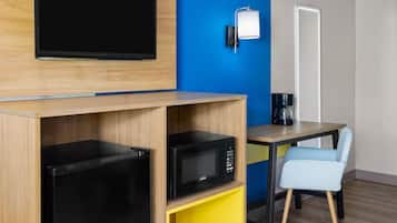 A compact kitchenette with a microwave, a coffee maker, and a small refrigerator.