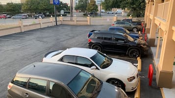 A parking lot with several cars, a sign for 'America's Best Value Inn', and a building with a beige facade.