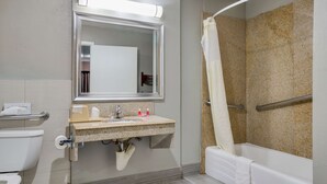 Ein Badezimmer mit Toilette, Waschbecken, Spiegel und Badewanne.