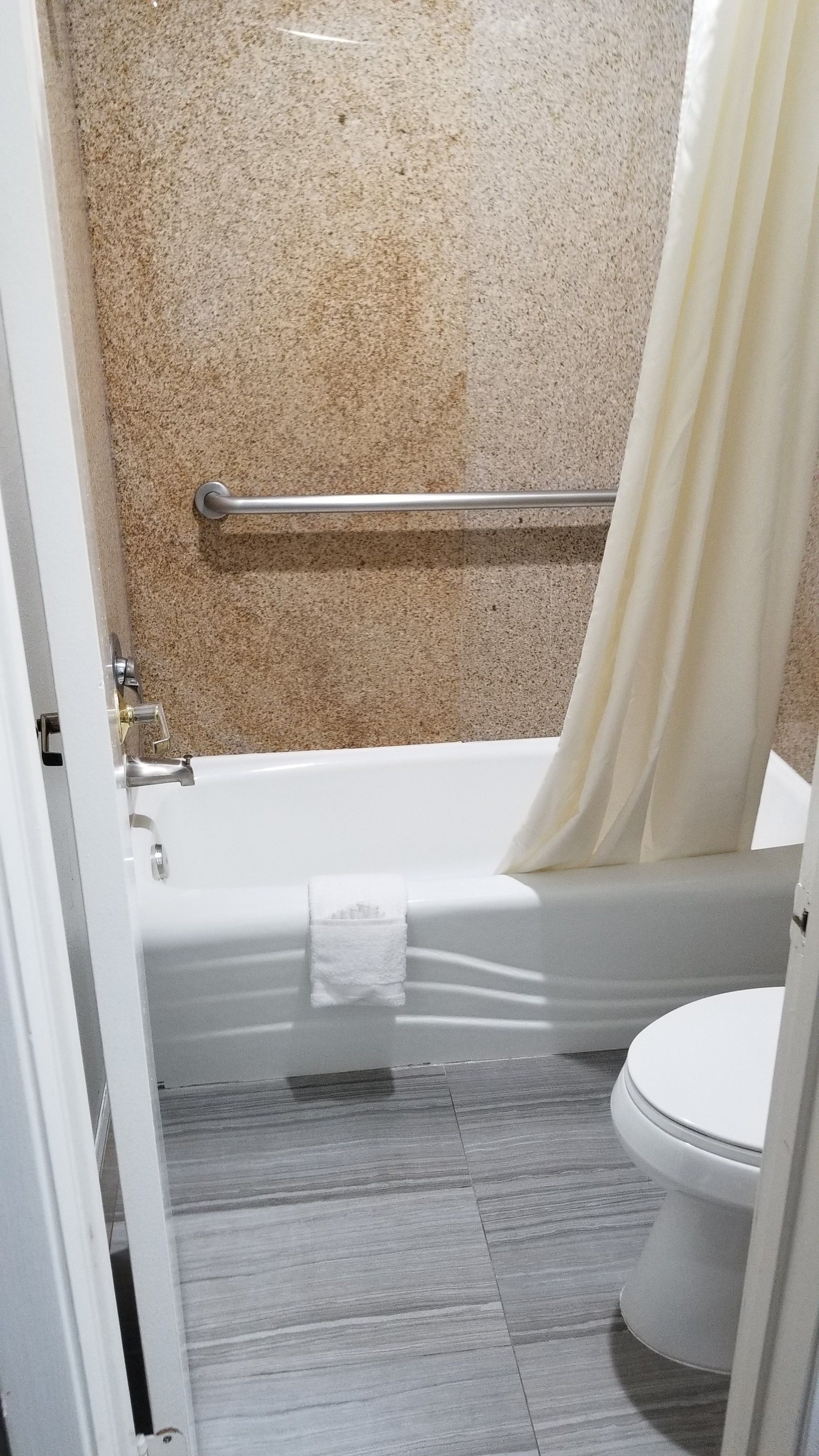 A bathroom with a bathtub, toilet, and a shower curtain.