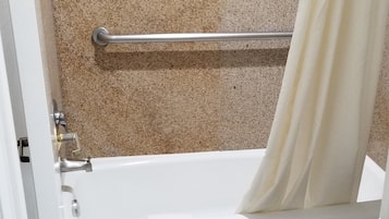 A bathroom with a bathtub, toilet, and a shower curtain.