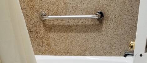 Un baño con inodoro blanco, bañera y cortina de ducha.