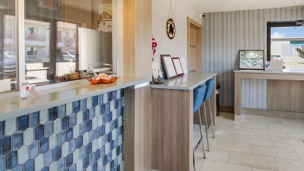 Eine moderne Küche mit Fliesenrückwand, Holzschränken und einer Bar mit Sitzgelegenheiten.