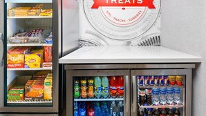 Un distributeur automatique proposant des collations et des boissons, notamment des marques comme Snickers, Doritos et Fanta.