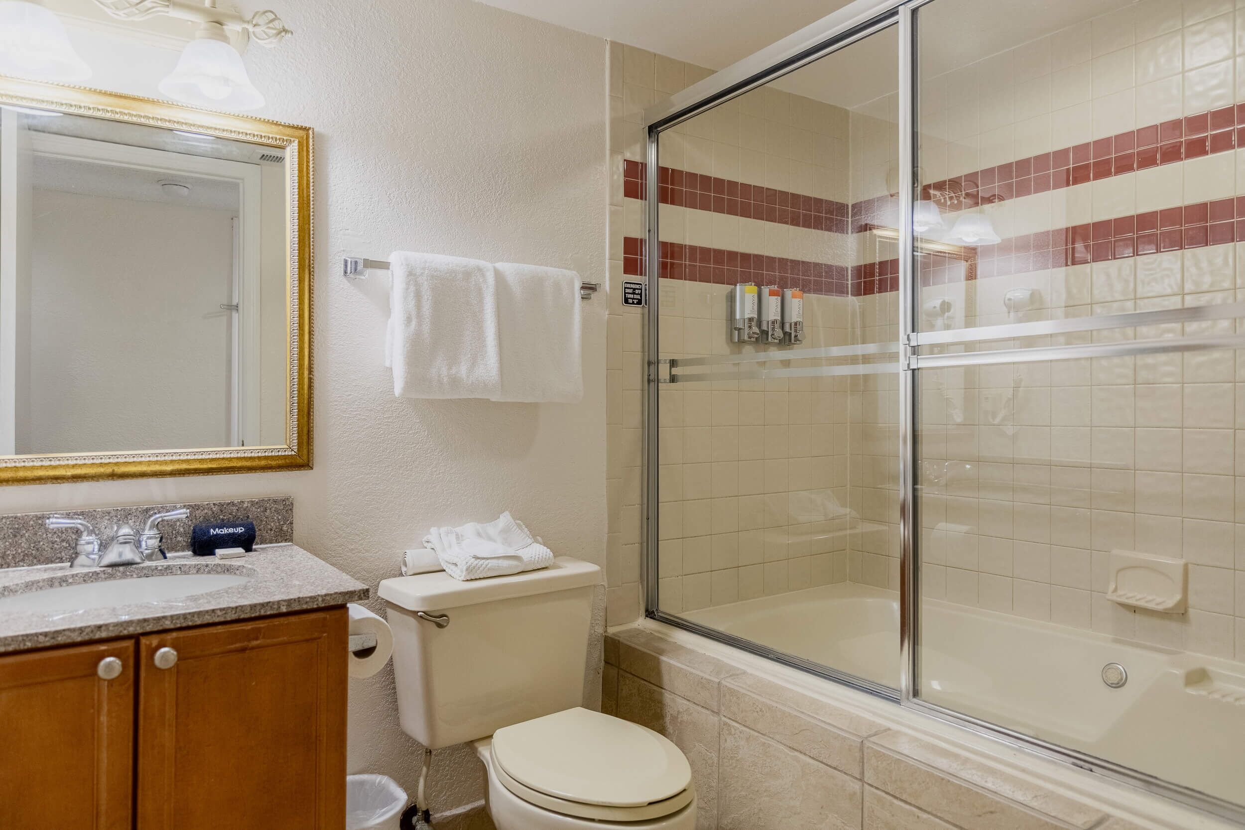 Une salle de bain équipée d’un lavabo, de toilettes et d’une douche à parois de verre.