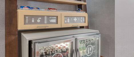 Un mini bar con aperitivos y un refrigerador para bebidas.