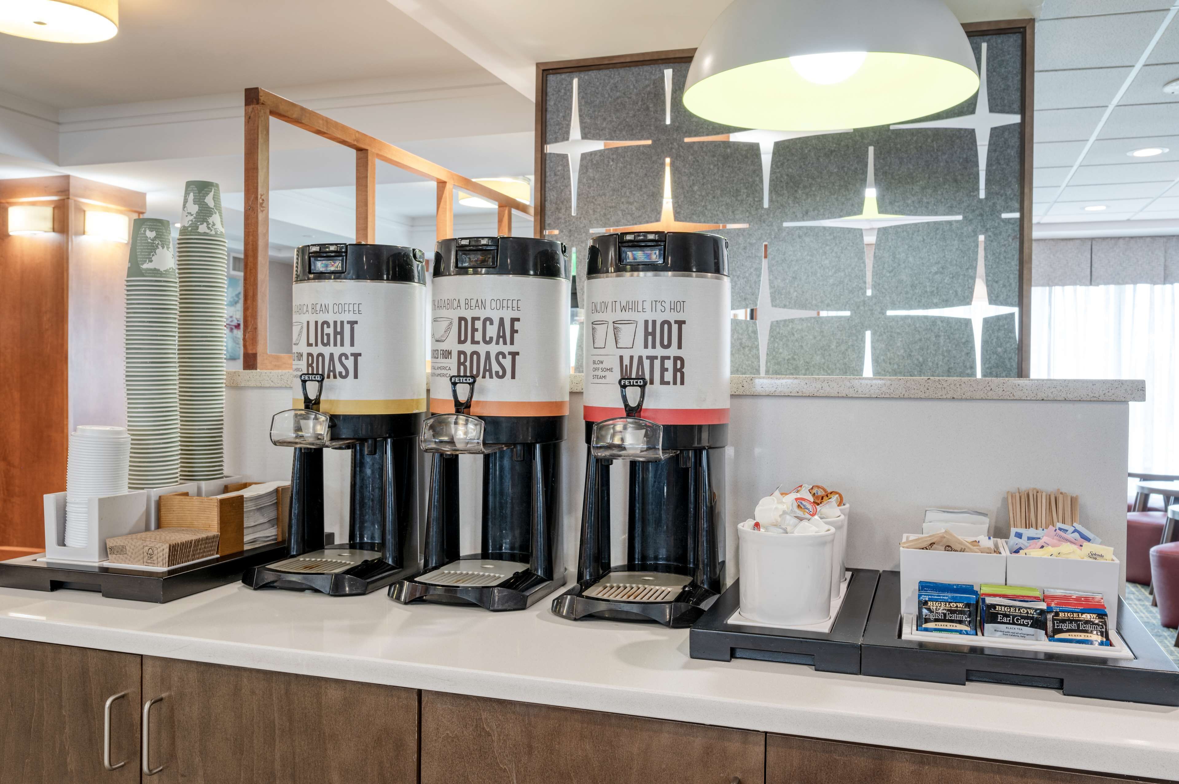 A coffee station with three coffee dispensers labeled "Light Roast," "Decaf Roast," and "Hot Water."
