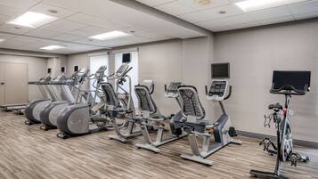 Ein Fitnessraum mit Laufbändern, Crosstrainern und einem Ergometer.