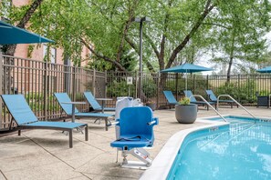 Una piscina al aire libre de temporada, sombrillas, tumbonas