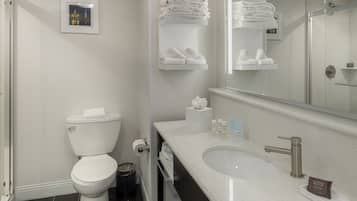 A modern bathroom with a toilet, sink, and towel racks.