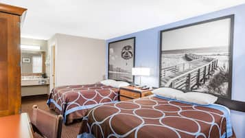 Habitación de hotel con dos camas, un escritorio, un aparador y un amplio ventanal con vista a la playa.