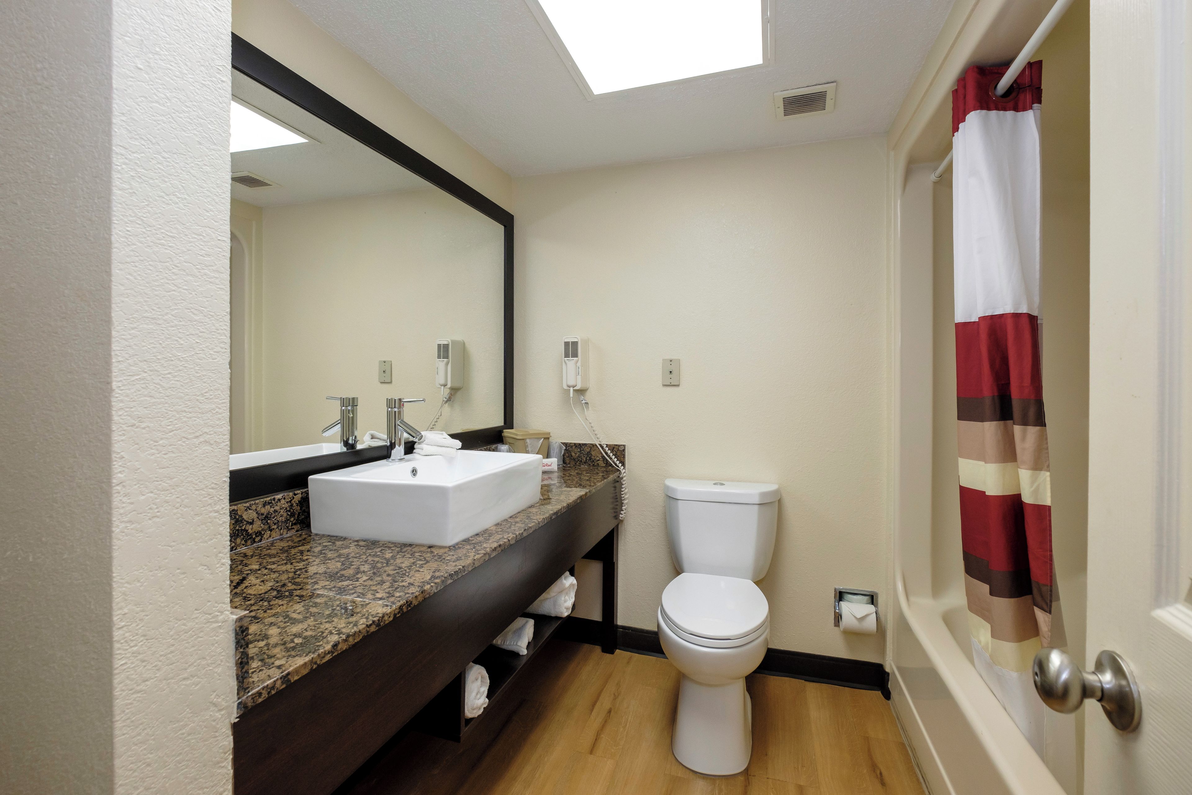 Un baño con lavamanos blanco, inodoro y cortina de ducha.