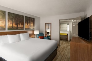 A hotel room with a large bed, a TV, a desk, and a chair. - Days Inn by Wyndham Clanton AL (Clanton)