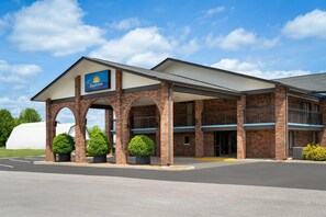 A Days Inn with a brick facade, multiple arches, and a parking lot. - Days Inn by Wyndham Clanton AL (Clanton)
