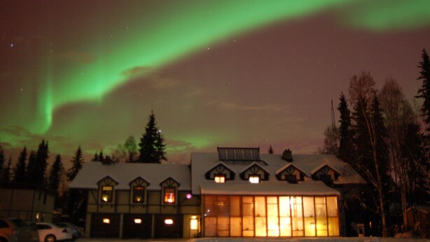 A lodge with multiple windows and a snow-covered roof, surrounded by trees. - 7 Gables Inn & Suites (Fairbanks)