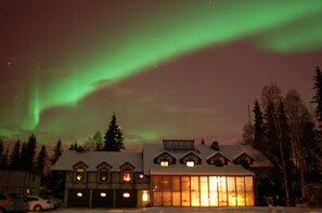A lodge with multiple windows and a snow-covered roof, surrounded by trees. - 7 Gables Inn & Suites (Fairbanks)
