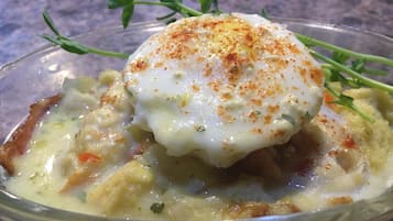 Un plato con un huevo escalfado, adornado con hierbas y especias.