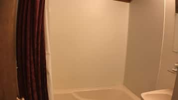 A bathroom with a wooden ceiling, a bathtub, and a sink.