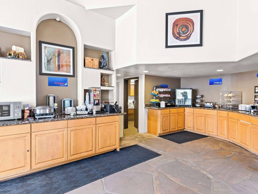 A modern kitchen with granite countertops, wooden cabinets, and a stone floor.