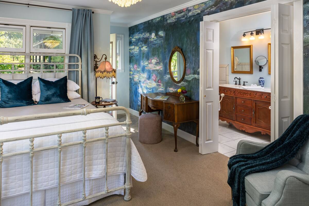 A bedroom with a bed, dresser, and vanity.