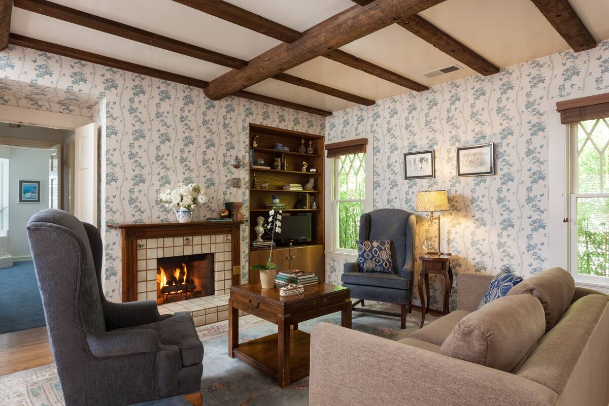 A living room with a fireplace, a bookshelf, a sofa, and a chair.