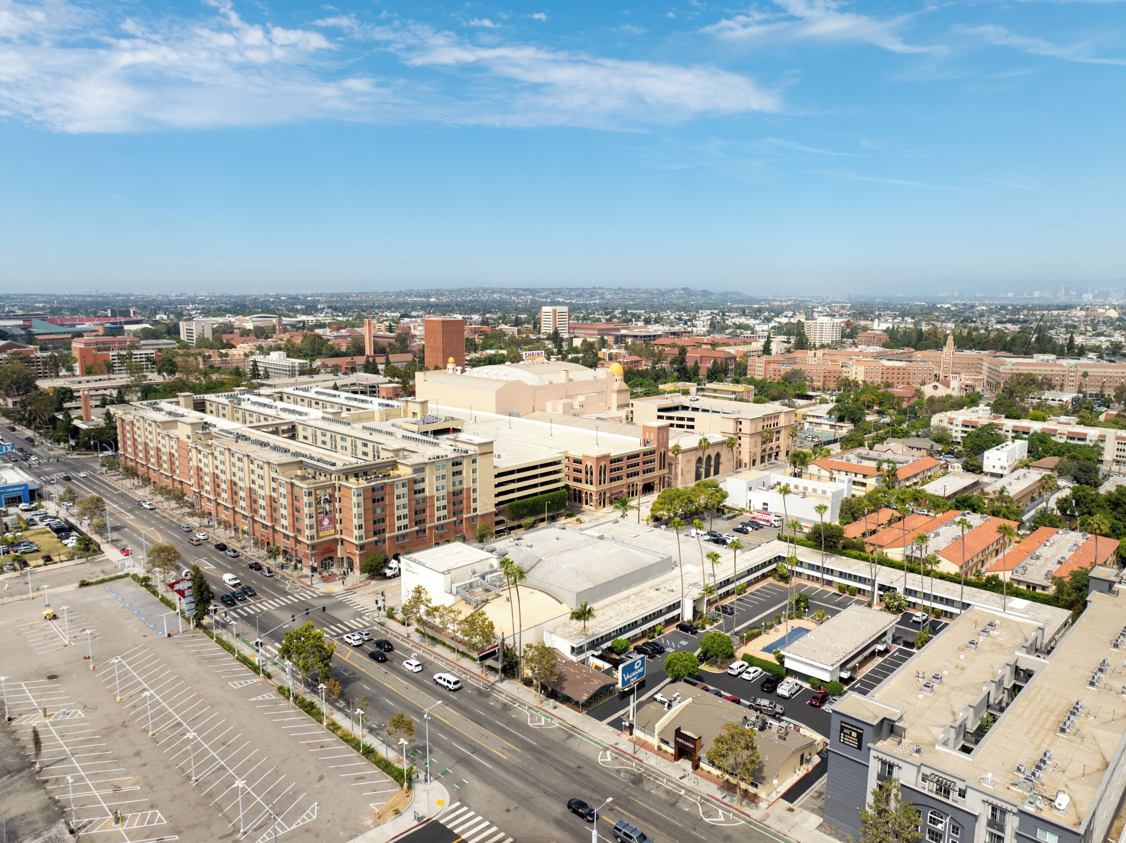 A cityscape with a prominent building featuring a large parking lot and a clear view of the surrounding urban area.