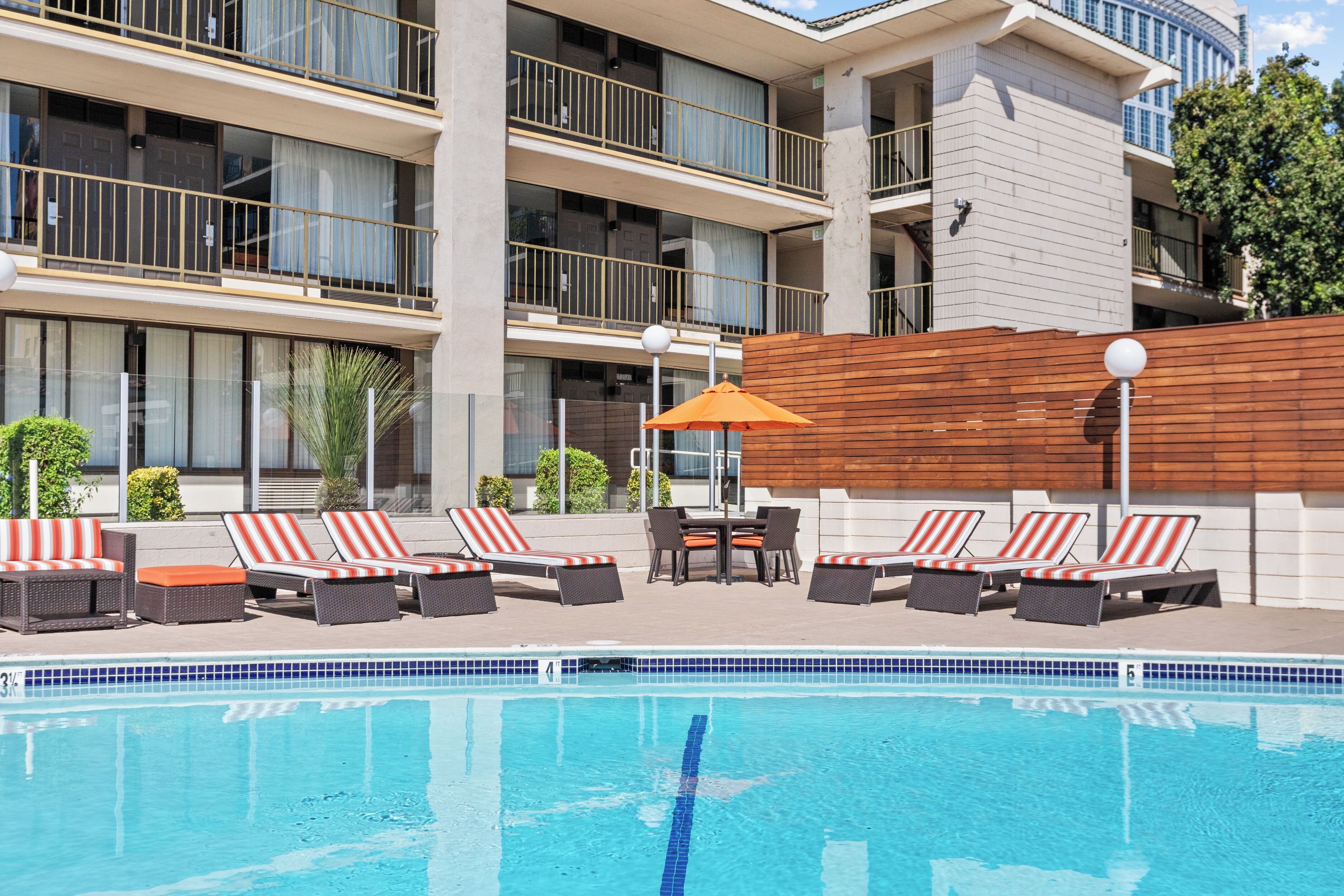 A swimming pool with lounge chairs and a wooden deck.