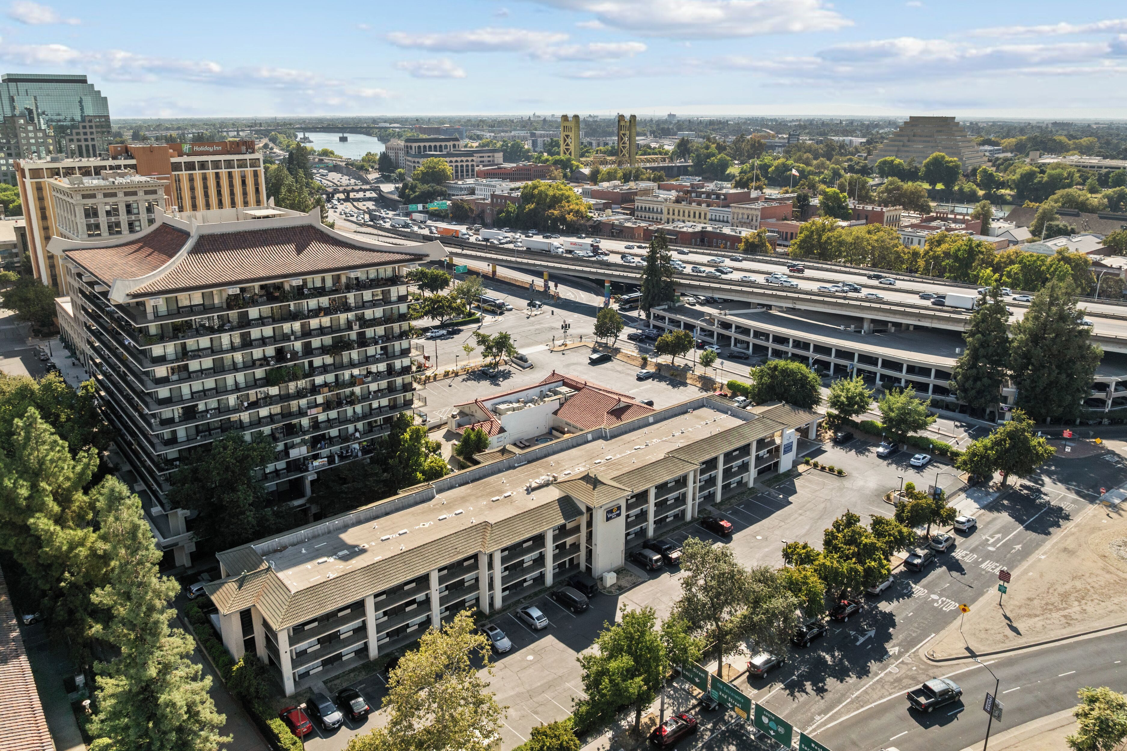 A multi-story parking garage with several levels of parking, surrounded by buildings and trees.