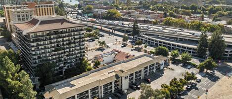 A multi-story parking garage with several levels of parking, surrounded by buildings and trees.