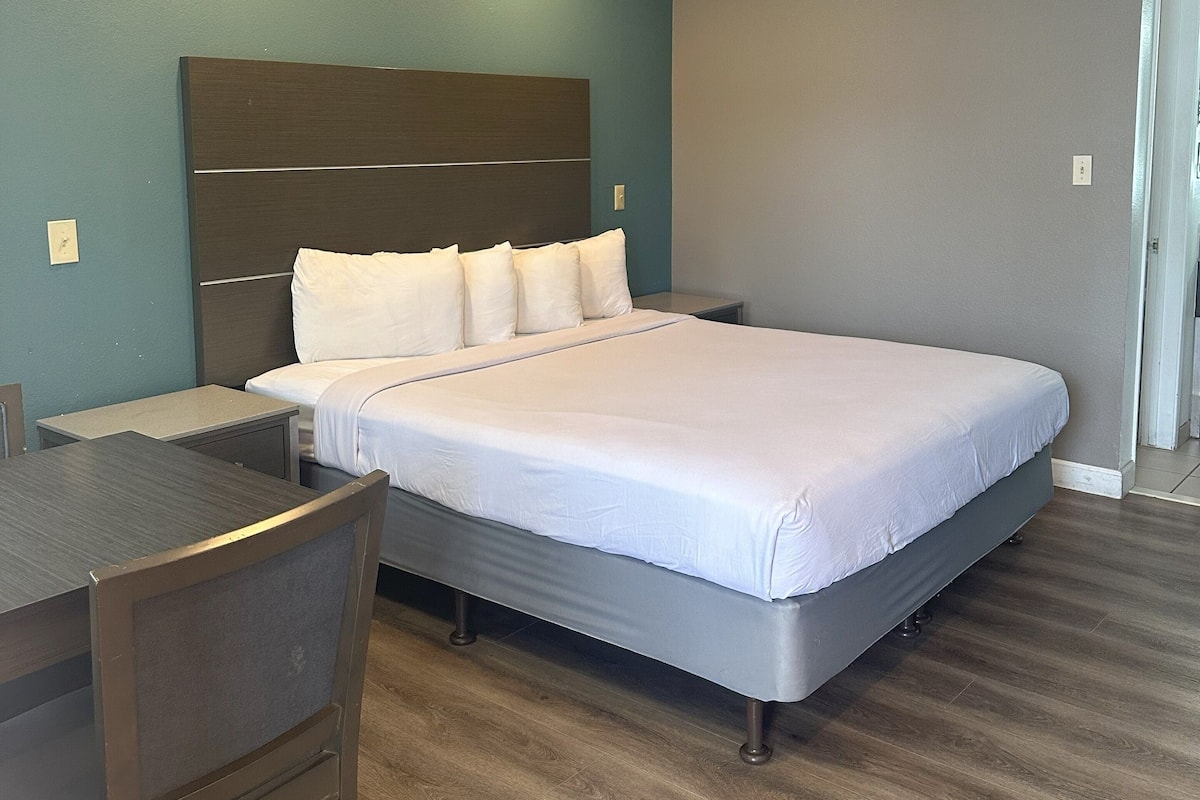 Une chambre d’hôtel avec un grand lit, un bureau et une chaise.