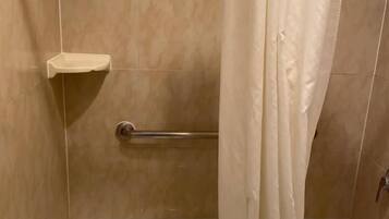 Une salle de bain avec une baignoire, un rideau de douche, une serviette et un porte-savon.