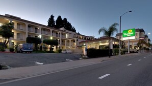 A hotel with multiple balconies, a parking lot, and a sign for Vagabond Inn.