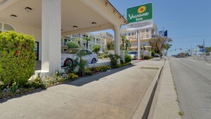 A Vagram Inn with a gas station, a covered parking area, and a row of buildings in the background.
