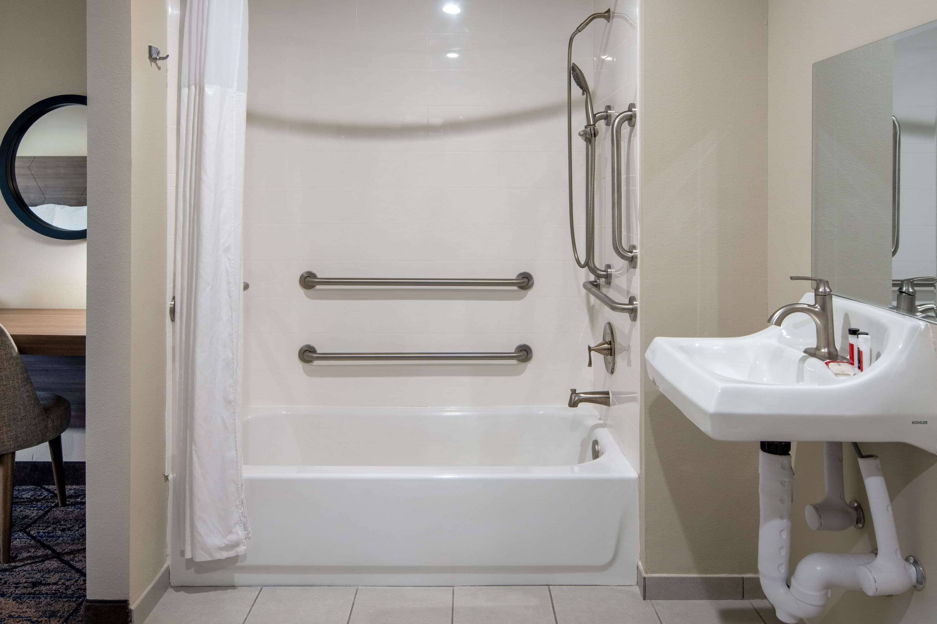A modern bathroom with a white bathtub, a sink, and a shower.