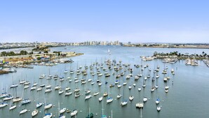 A marina filled with numerous boats, a distant city skyline, and a clear blue sky. - Sea Harbor Hotel (San Diego)
