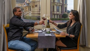 A dining table with a wine bottle and glasses, a laptop, and a menu. - Carter House Inns (Eureka)