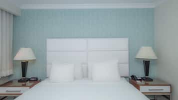 Ein Hotelzimmer mit einem großen Bett, zwei Nachttischen, zwei Lampen und einer Wand mit Muster.