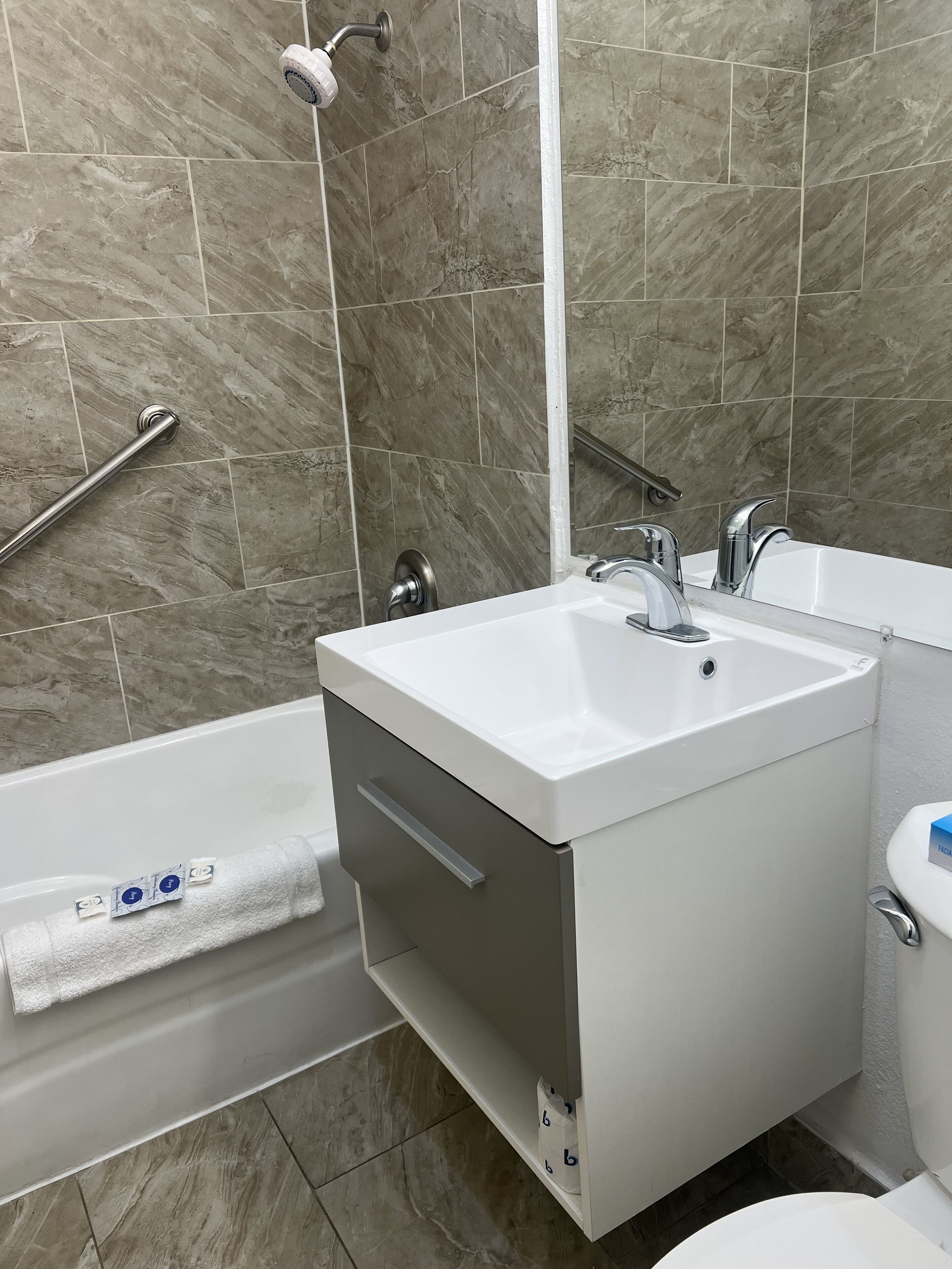 A bathroom with a white sink, a bathtub, and a toilet.