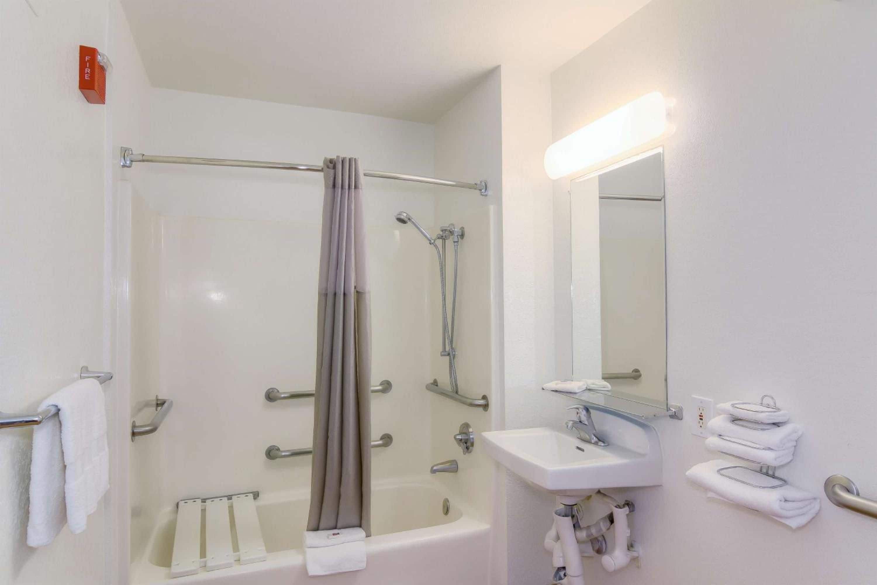 Un baño con bañera, ducha, lavabo y espejo.
