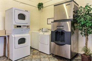 A laundry area with a front-loading washer, a top-loading dryer, and an ice dispenser.
