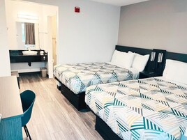 Una habitación de hotel con dos camas, un escritorio y una silla.