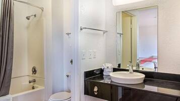 Une salle de bain avec une baignoire, des toilettes et un lavabo avec un miroir au-dessus.