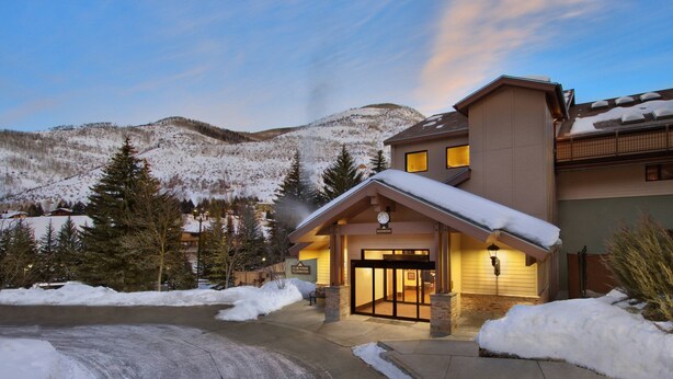 A hotel entrance with a snow-covered landscape and mountains in the background. - Marriott's StreamSide Evergreen at Vail (Vail)