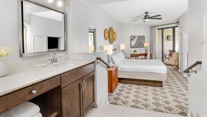 A modern hotel room with a large mirror, a double bed, a desk with a chair, and a ceiling fan. - Marriott's Sabal Palms (Orlando)