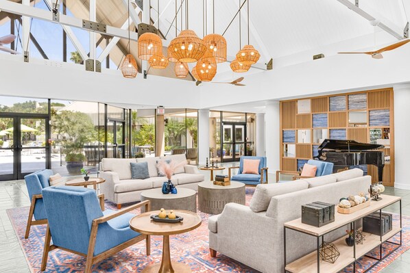 A spacious lobby with modern furniture, large windows, and a grand piano. - Marriott's Sabal Palms (Orlando)