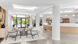 A spacious lobby with a reception desk, seating area with chairs, and large windows offering a view of the outdoors. - Marriott's Sabal Palms (Orlando)