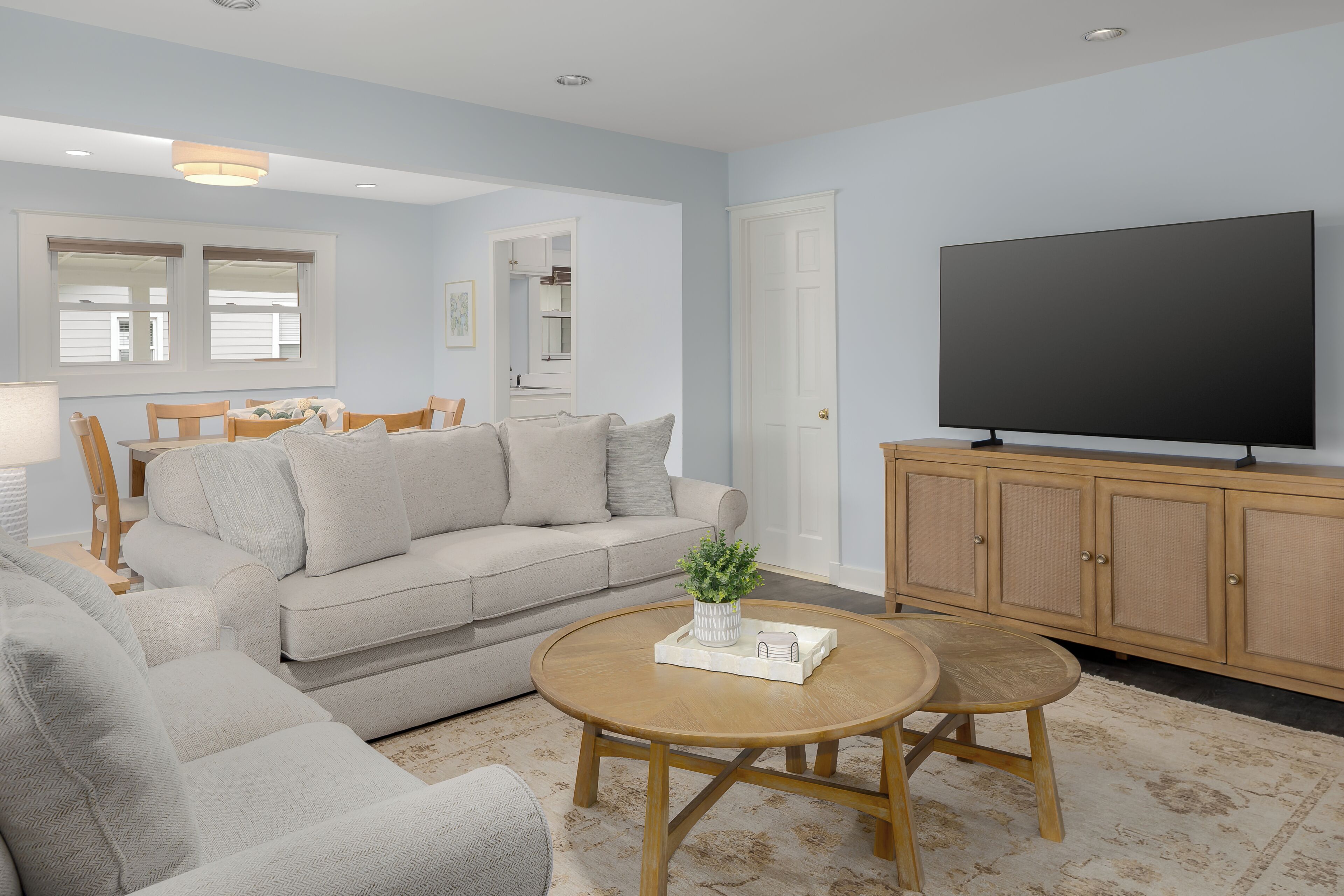 A living room with a sofa, coffee table, TV, and wooden cabinet.