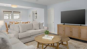 A living room with a sofa, coffee table, TV, and wooden cabinet.