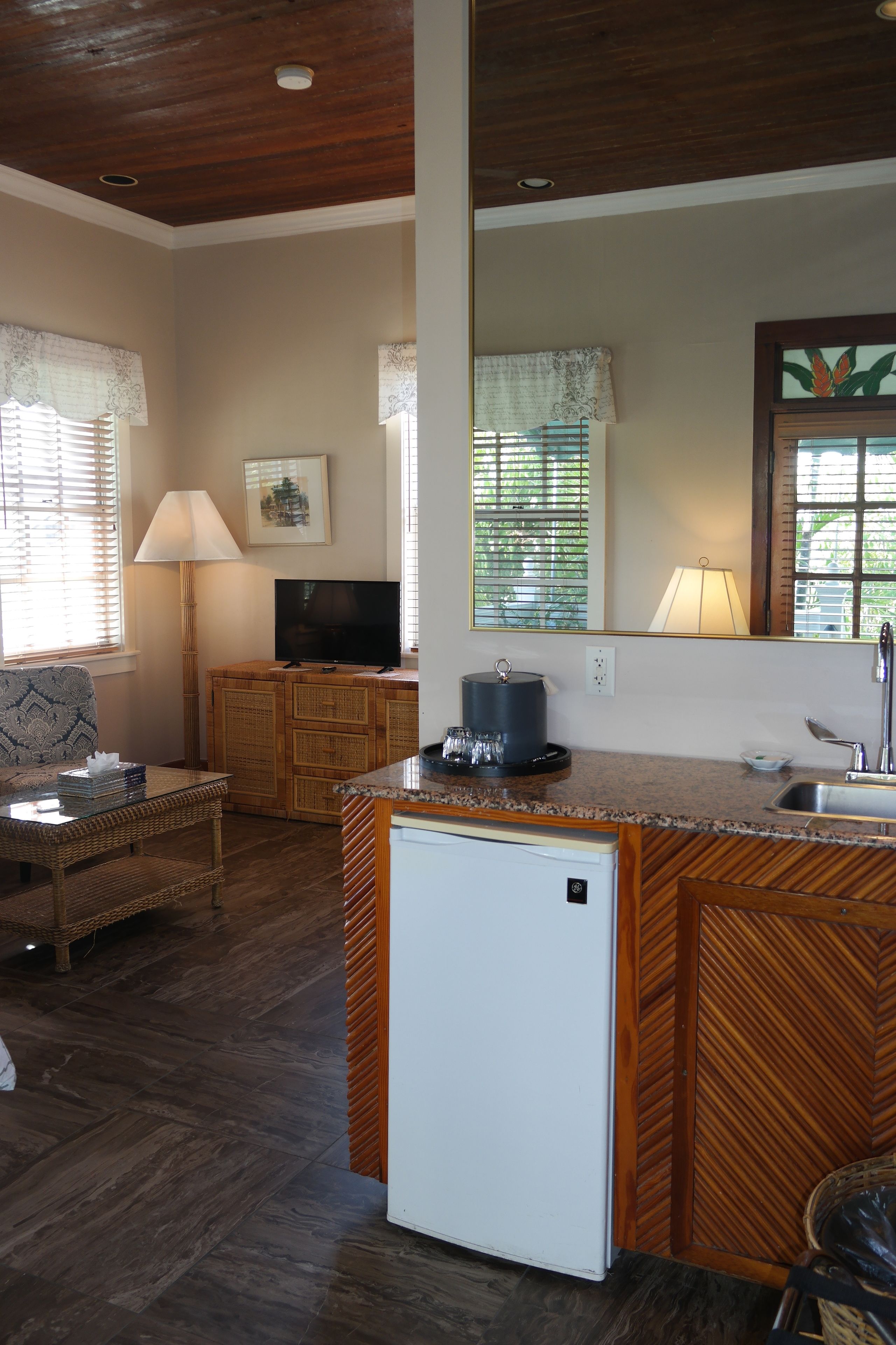 Un espacio habitable compacto con kitchenette, televisor, mesa de comedor y sofá.