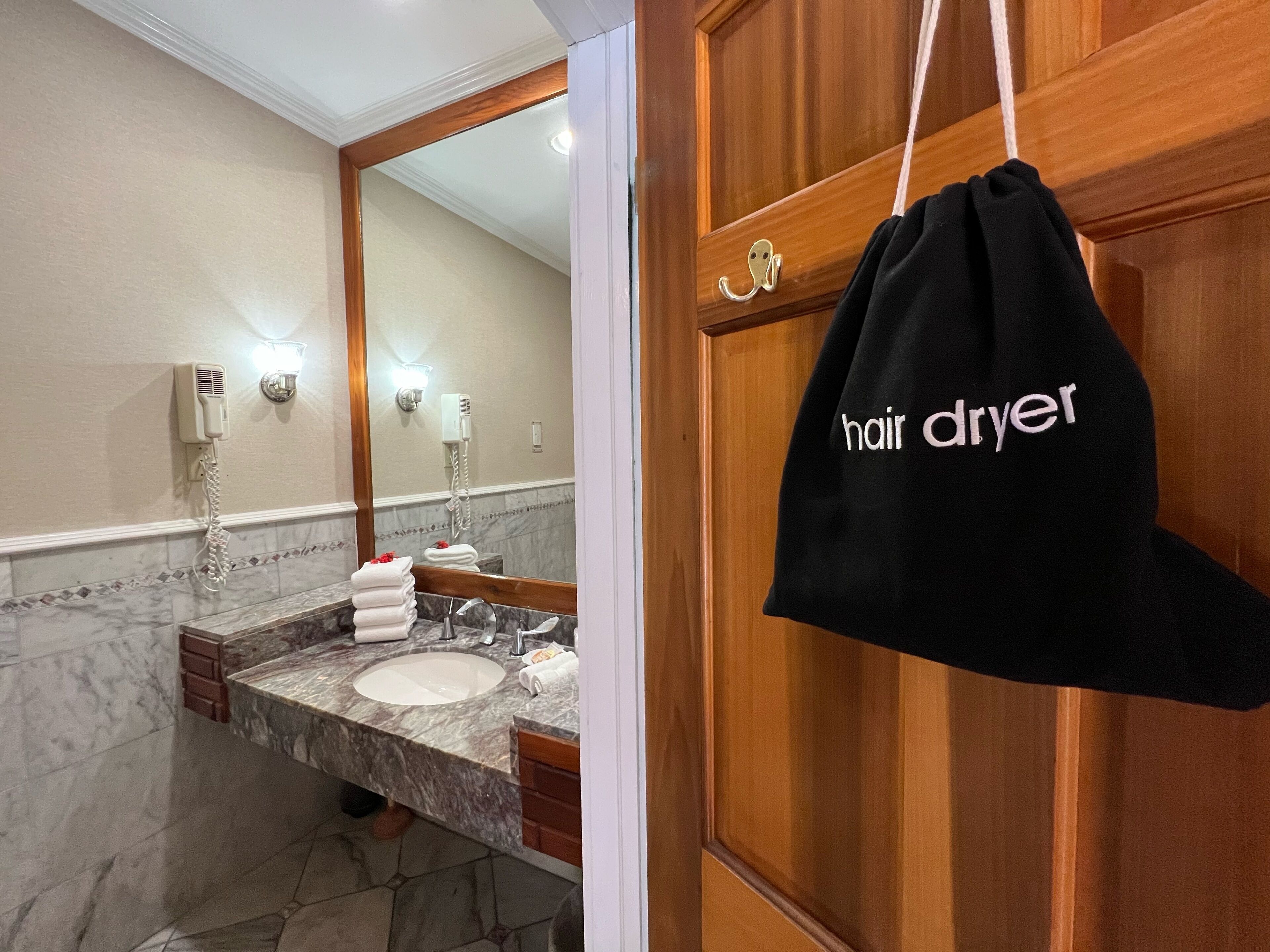 Une salle de bain avec un lavabo en marbre, un miroir et un porte-serviettes.